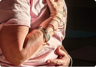 Close-up of hands holding a mala bead necklace with a yellow tassel during a meditation retreat